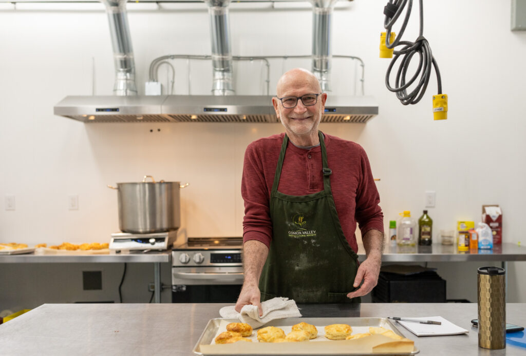 a chef prepares fresh cheese scones in a large commercial kitch.