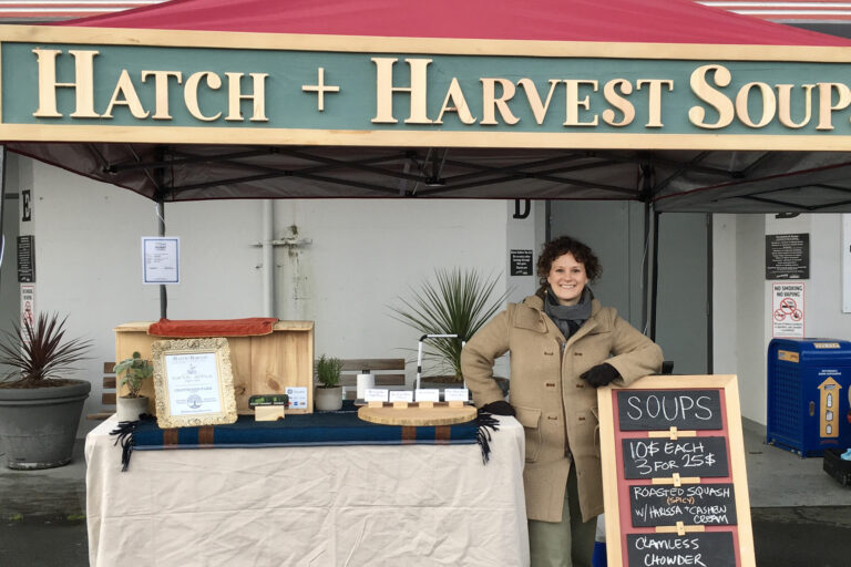 A soup vendor poses in front of a market stall outside of the Port Alberni Dock+