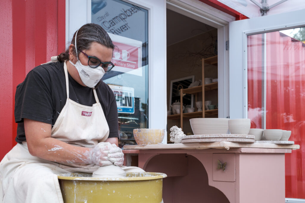 Emma Heitzmann, artist and owner of Tin Can Pottery Shop, works outside her Rail Yard Market shop during its grand opening.